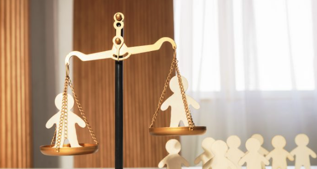 5 Claves legales en Derecho de Familia Torrevieja: mazo de juez sobre mesa con libro de leyes y figuras de madera que representan la unidad familiar.